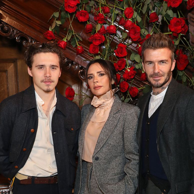 Image may contain: Brooklyn Beckham, David Beckham, Victoria Beckham, Clothing, Coat, Jacket, Blazer, Adult, and Person