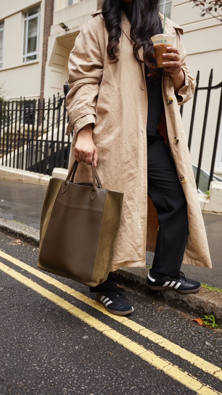 Image may contain Clothing Coat Cup Footwear Shoe Accessories Bag Handbag Adult Person Pedestrian and Overcoat