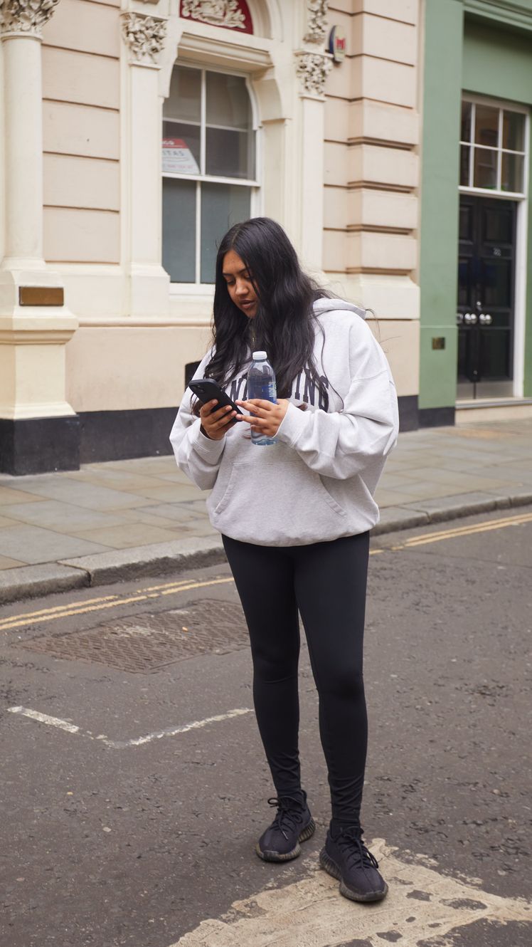 Image may contain Person Teen Electronics Mobile Phone Phone Clothing Footwear Shoe Pedestrian and Fire Hydrant