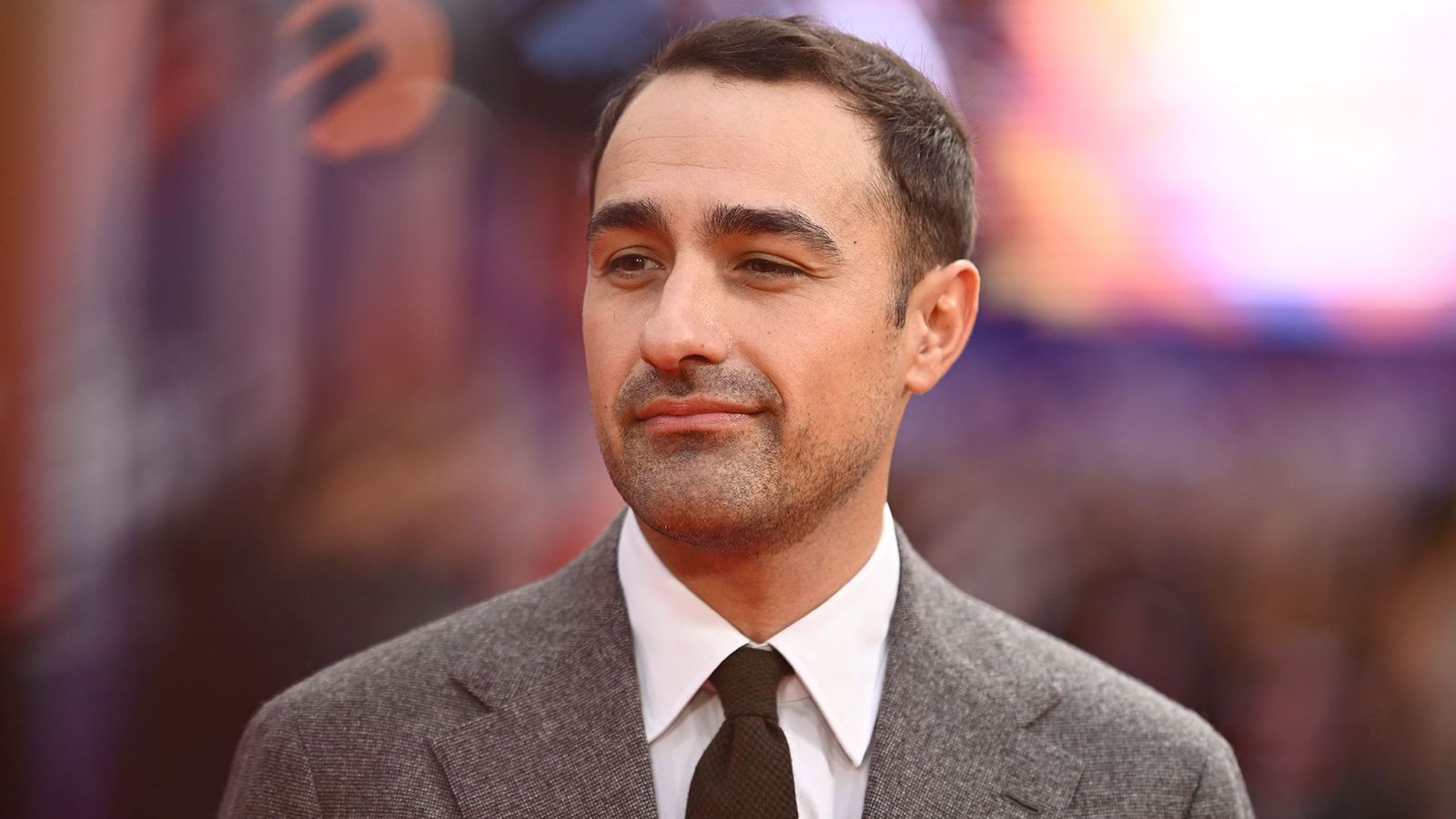 Image may contain Crew Cut Hair Person Head Face Photography Portrait Adult Accessories Formal Wear and Tie