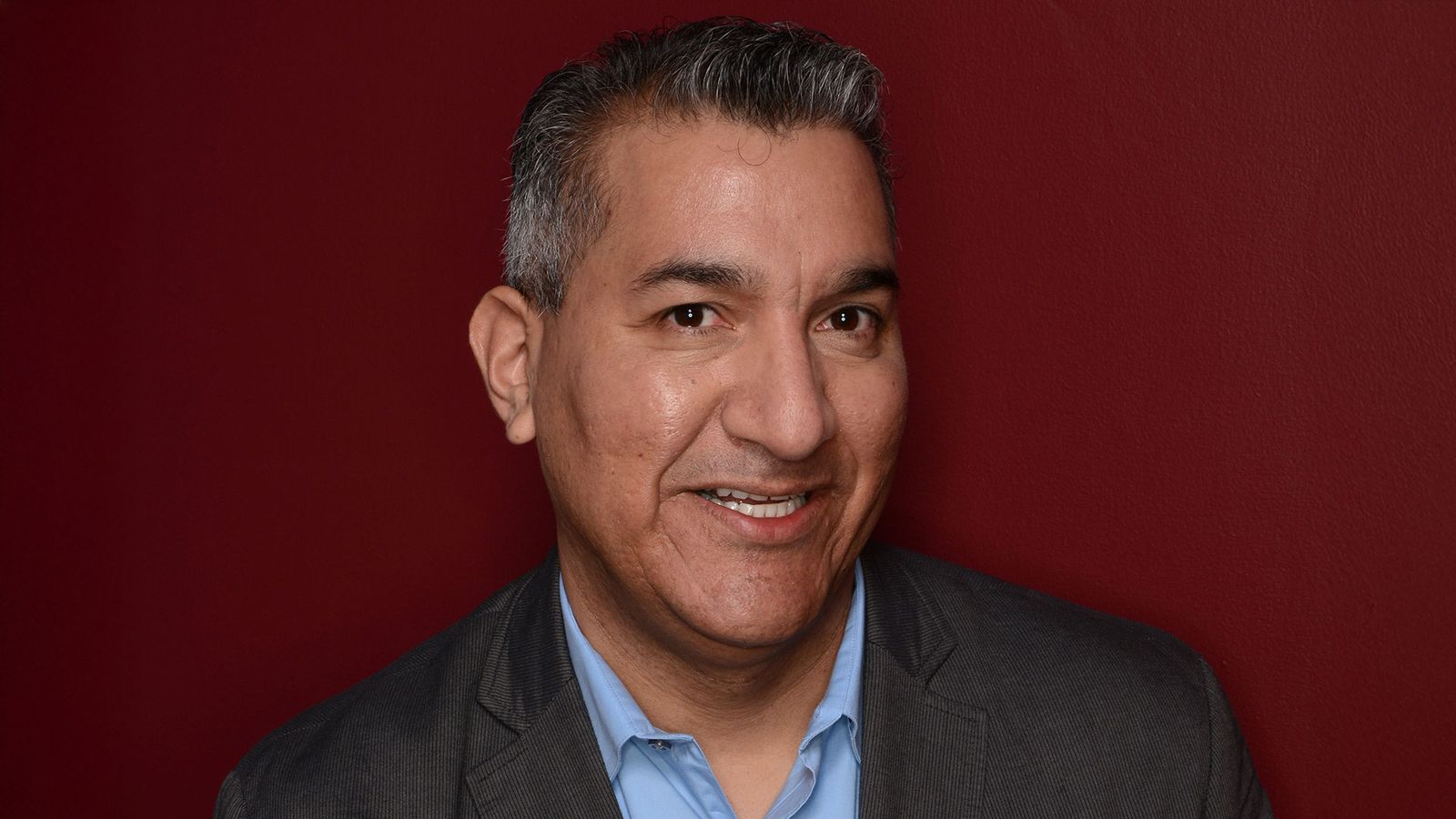 Image may contain Head Person Face Happy Smile Dimples Photography Portrait Adult Clothing Formal Wear and Suit